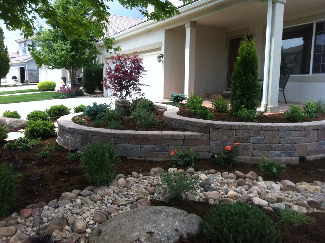 Photo of raised pavestone garden beds with an elegant and modern xeriscape design in Leydon Ranch, Arvada, Colorado. 