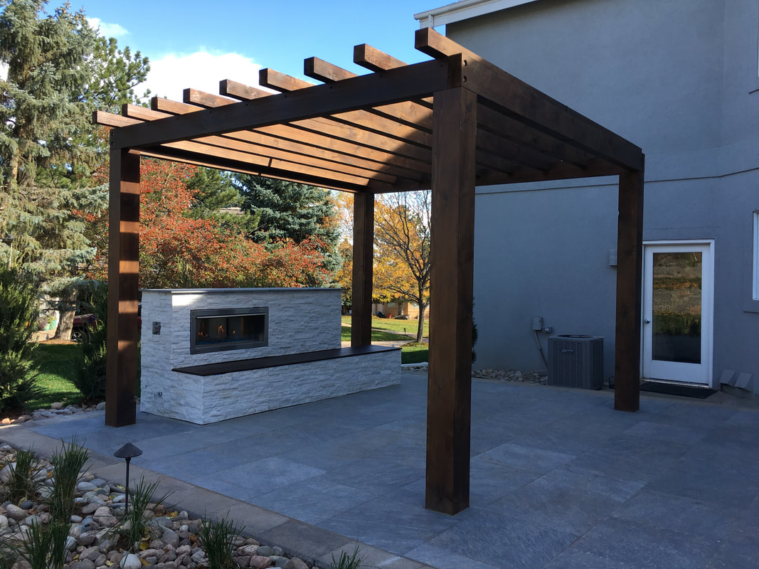 Picture of a modern Denver landscape design with a pergola and outdoor fire place. 