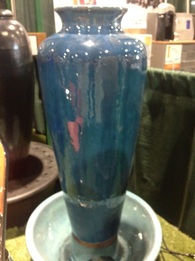 Picture of a slim indoor table top jar fountain with turquoise glaze finish. 