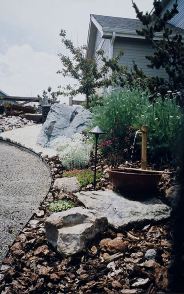 Xeriscape garden idea with gravel walkway, custom stone selections and a self contained outdoor water fountain. 