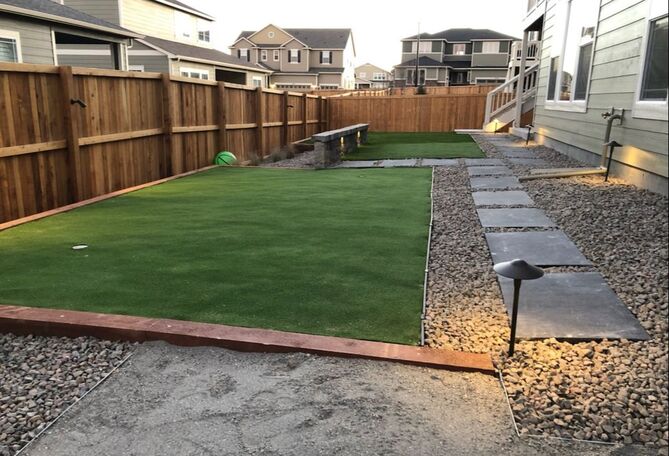 Denver dog-friendly landscape design with turf grass, stone walkway and rock and gravel ground covering. Low voltage outdoor lighting features accent this design. 